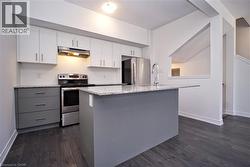 Modern kitchen featuring white upper cabinetry and grey base cabinetry - 