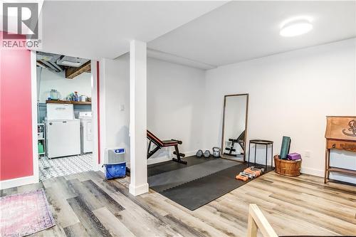 Spacious finished basement featuring wood-finish flooring and a dedicated laundry area with patterned tile flooring - 218 Richardson Drive Unit# 26, Port Dover, ON 