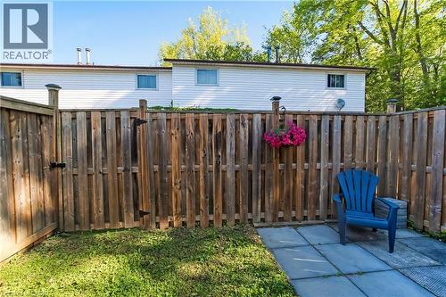Private backyard featuring a wooden privacy fence, a paved patio area, and a grassy section - 218 Richardson Drive Unit# 26, Port Dover, ON 