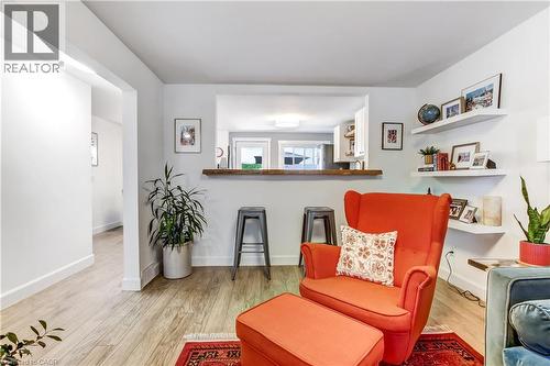Living area with wood-finish flooring, white walls, and a pass-through opening featuring a wood-finish bar top - 218 Richardson Drive Unit# 26, Port Dover, ON 