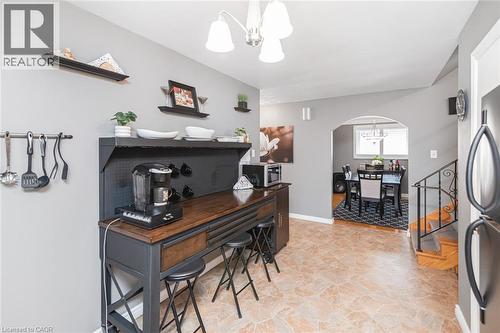 Open-concept kitchen and dining areas featuring tile flooring, a built-in coffee bar, and an arched doorway - 366 Berkindale Drive, Hamilton, ON 