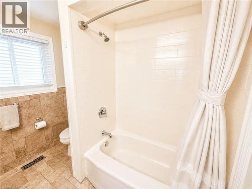 Bathtub with white subway tile surround and chrome fixtures - 366 Berkindale Drive, Hamilton, ON 