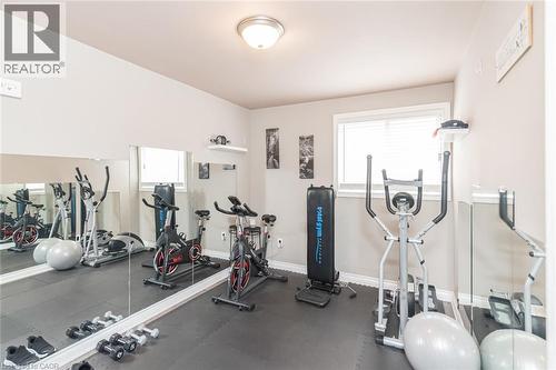 Dedicated exercise room featuring wall-to-wall mirrors, a window with blinds, and recessed lighting - 366 Berkindale Drive, Hamilton, ON 