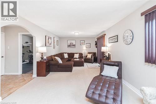 Spacious living area featuring light-toned carpeting, neutral wall finishes, and a textured ceiling - 366 Berkindale Drive, Hamilton, ON 