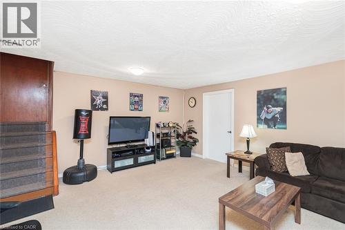 Carpeted room with a textured ceiling, a light-toned wall finish, and a white interior door with dark hardware - 366 Berkindale Drive, Hamilton, ON 