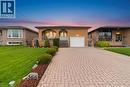 Brick exterior featuring an arched entryway, integrated garage with white door, and a paved driveway - 366 Berkindale Drive, Hamilton, ON 