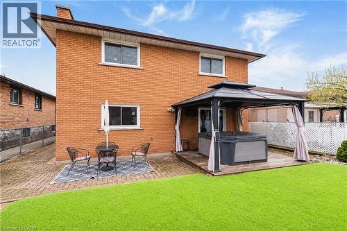 Expansive backyard featuring a lush lawn, brick exterior, and a dedicated patio area - 366 Berkindale Drive, Hamilton, ON 