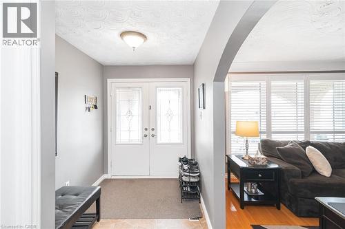 Entry foyer featuring double white entry doors with decorative glass panels, a semi-flush mount ceiling fixture, and neutral wall paint - 366 Berkindale Drive, Hamilton, ON 