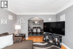 Living space with light gray walls and wood-finish flooring - 