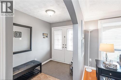 Entryway featuring double doors with decorative glass inserts, ceramic tile flooring, and a flush-mount ceiling light fixture - 366 Berkindale Drive, Hamilton, ON 
