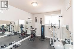 Dedicated exercise room featuring wall-to-wall mirrors, a window with blinds, and recessed lighting - 