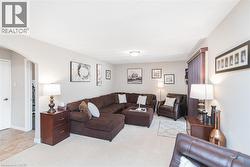 Spacious living area featuring light-toned carpeting and neutral wall tones - 