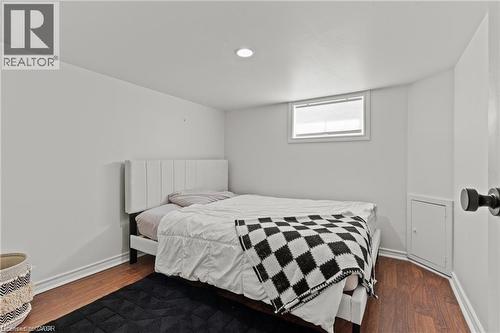 Room featuring wood-finish flooring, white painted walls, and a single recessed ceiling light - 33 Huxley Avenue N, Hamilton, ON 