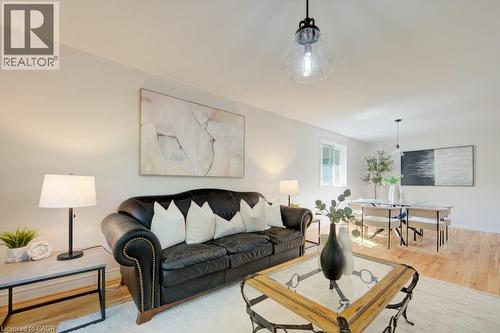 Open-concept living area featuring light wood-finish flooring, white walls, and recessed lighting - 60 Mayfield Avenue, Waterloo, ON 
