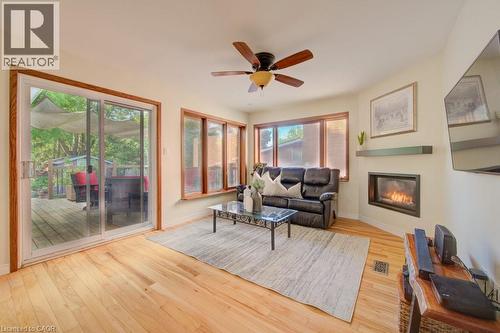 Hardwood-finish flooring throughout, featuring a corner-mounted fireplace with a floating mantel - 60 Mayfield Avenue, Waterloo, ON 