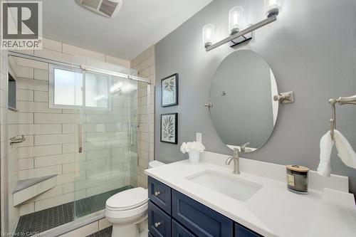 Bathroom featuring a glass-enclosed shower with a built-in bench, subway tile surround, and dark tile flooring - 60 Mayfield Avenue, Waterloo, ON 