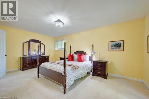 Carpeted room featuring a white door, a single window with blinds, and a ceiling-mounted light fixture - 60 Mayfield Avenue, Waterloo, ON 