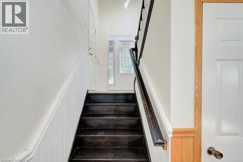 Dark-toned staircase with white risers and a contrasting dark handrail - 60 Mayfield Avenue, Waterloo, ON 