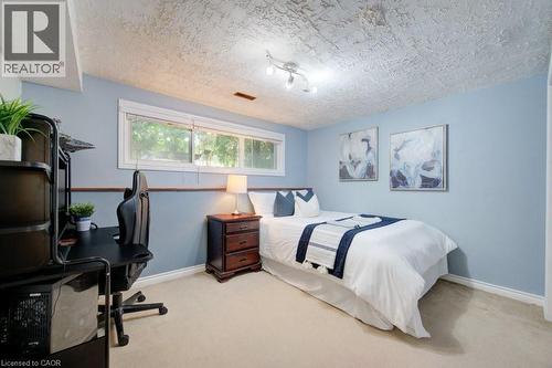 Bedroom featuring light blue walls with a chair rail, a multi-pane window, and carpet flooring - 60 Mayfield Avenue, Waterloo, ON 