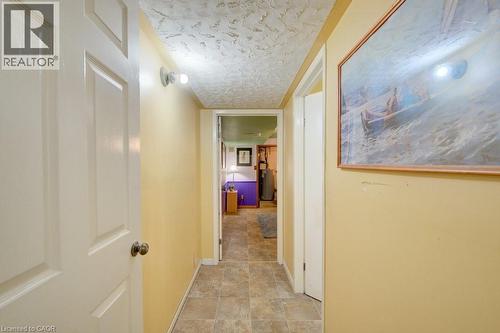 Interior hallway featuring wood-finish flooring, light yellow walls, and a textured ceiling - 60 Mayfield Avenue, Waterloo, ON 