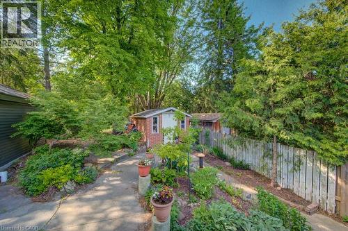 Landscaped garden path featuring mature trees and established plantings - 60 Mayfield Avenue, Waterloo, ON 