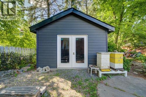 Detached outbuilding with dark siding and a contrasting dark roofline - 60 Mayfield Avenue, Waterloo, ON 