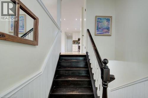 Dark-stained wood stairs with a matching handrail and white balusters - 60 Mayfield Avenue, Waterloo, ON 