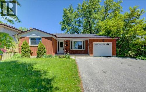 Brick exterior with a peaked roofline, attached garage, and a concrete driveway - 80 Lower Canada Crescent, Kitchener, ON 