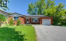Brick exterior with a peaked roofline, attached garage, and a concrete driveway - 80 Lower Canada Crescent, Kitchener, ON 