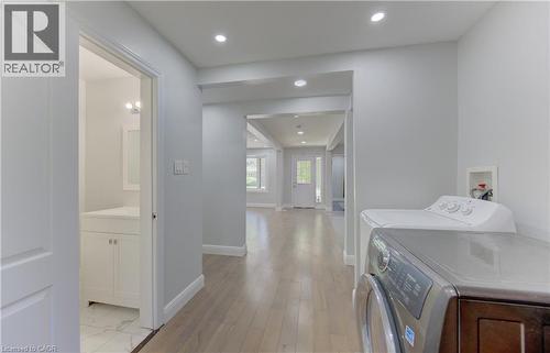 Open concept main floor with light wood-finish flooring extending through the hallway and into a spacious living area - 80 Lower Canada Crescent, Kitchener, ON 