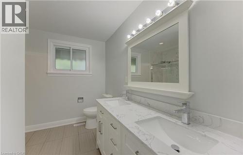 Bathroom featuring a double vanity with stone-finish countertop, dual integrated sinks, and chrome faucets - 80 Lower Canada Crescent, Kitchener, ON 