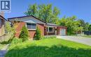 Red brick exterior home featuring a single garage door, a concrete driveway, a front lawn, and mature trees - 80 Lower Canada Crescent, Kitchener, ON 