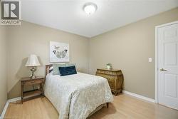 Bedroom featuring light wood-finish flooring, neutral wall paint, and white baseboards - 