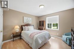 Bright room featuring light wood-finish flooring, a window with white trim, and neutral-toned walls - 