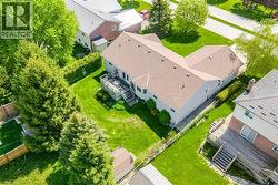 Expansive rear yard featuring a large deck, mature trees, and manicured lawn - 