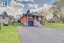 Brick exterior with a covered porch, white railing, and a dark garage door - 4 Ronald Road, Cambridge, ON 