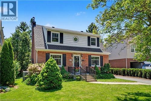 Brick facade residence featuring a front lawn with mature landscaping - 2068 Wellington Avenue, Burlington, ON 
