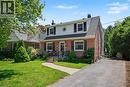 Brick and siding facade featuring a gabled roofline, front entry steps with wrought iron railings, and a paved driveway - 2068 Wellington Avenue, Burlington, ON 