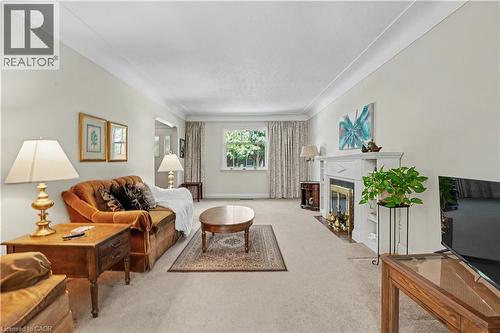 Spacious living area featuring light-toned walls, crown molding, and carpeting - 2068 Wellington Avenue, Burlington, ON 