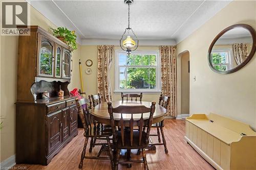 Dining area featuring wood-finish flooring, a pendant light fixture, and a window with exterior views - 2068 Wellington Avenue, Burlington, ON 