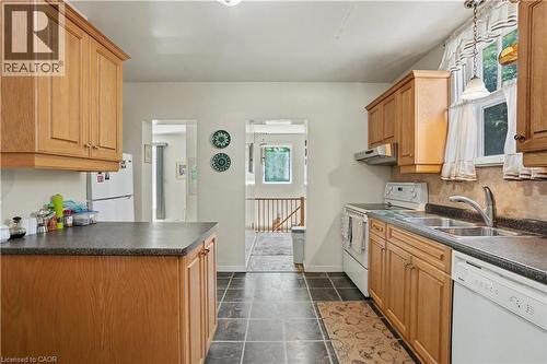 Kitchen featuring wood-finish cabinetry, dark countertops, and slate-finish floor tile - 2068 Wellington Avenue, Burlington, ON 