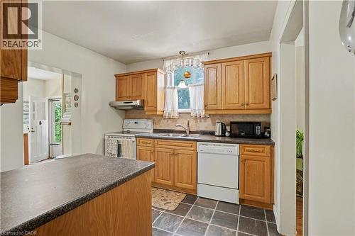 Kitchen featuring wood cabinetry, dark countertops, tile flooring, and a window above the sink - 2068 Wellington Avenue, Burlington, ON 