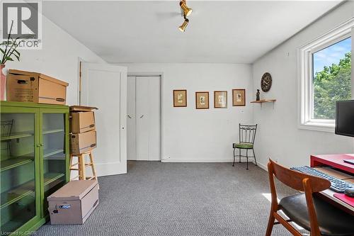 Interior room featuring a white ceiling and walls, gray carpet, a window with white trim, and a white door - 2068 Wellington Avenue, Burlington, ON 