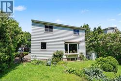 Rear exterior featuring horizontal siding, a bay window, and a ground-level window - 
