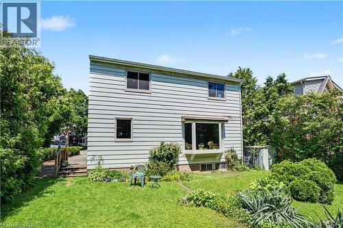 Rear exterior featuring horizontal siding, a bay window, and a ground-level window - 2068 Wellington Avenue, Burlington, ON 