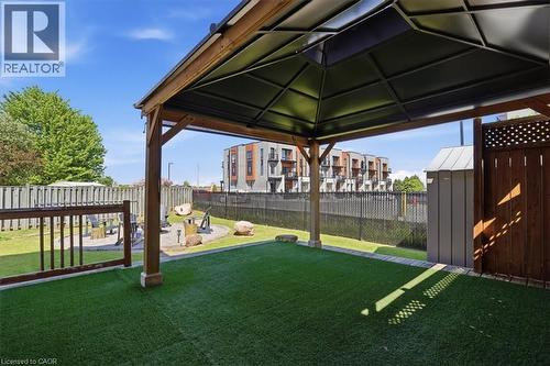Covered patio area with artificial turf, featuring a wood-frame gazebo and a privacy fence - 20 Ridgeway Crescent, Kitchener, ON - Outdoor