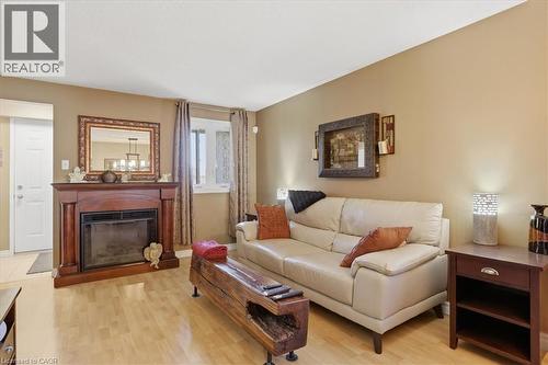 Living area featuring a prominent fireplace with a wood-finish mantel and surround - 20 Ridgeway Crescent, Kitchener, ON - Indoor Photo Showing Living Room With Fireplace