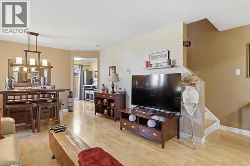 Open-concept living area featuring a contemporary chandelier, and a neutral color palette - 20 Ridgeway Crescent, Kitchener, ON - Indoor Photo Showing Living Room