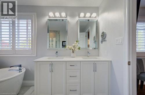 Dual vanity with white cabinetry, integrated sinks, chrome faucets, and quartz countertop - 7 Housler Lane, Cambridge, ON 
