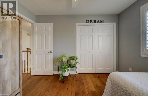Hardwood-finish flooring, white panel bi-fold closet doors, white panel interior door, painted walls, and white window shutters - 7 Housler Lane, Cambridge, ON 
